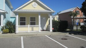 A yellow building with a white porch and a mailbox.