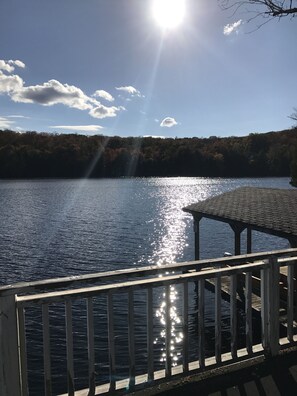 Escape to a serene lakeside retreat with a wooden deck leading to a covered gazebo.
