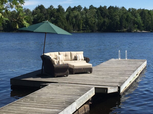 Relax on the lakeside dock with a wicker sofa and enjoy the serene surroundings.