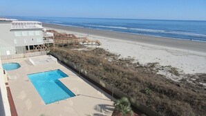 Un hotel frente al mar con piscina, acceso directo a la playa y vistas al océano.