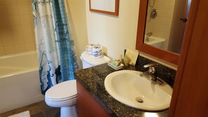 A bathroom with a bathtub, toilet, sink, and a shower curtain.