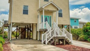 A two-story building with a covered entrance and a small porch.