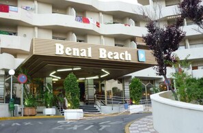 La entrada a Benal Beach con un letrero, una señal de no estacionamiento y una flecha direccional en la carretera.