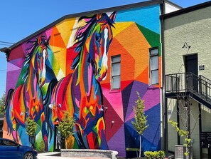 Un bâtiment orné d’une fresque murale éclatante et colorée représentant des chevaux.