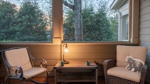 A cozy seating area with two chairs, a table, and a lamp.