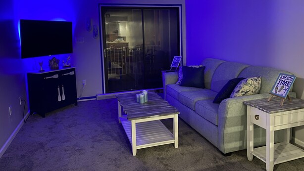 A living room with a flat-screen TV, a sofa, a coffee table, and a small side table. - Let the fun begin 🏖🏊‍♀️😁<br>Located between both beaches (Rehoboth)