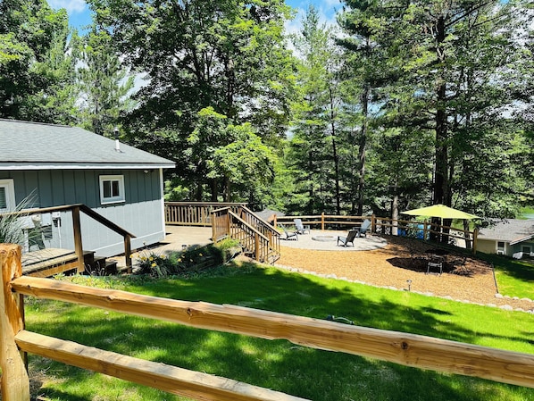 A wooden deck with a staircase leading to a covered patio area.