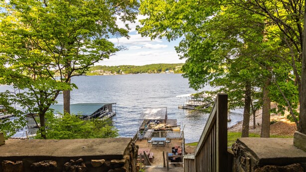 A view of a lake with a dock and a wooden staircase leading down to a docked boat. - Stunning Lake Front Home - Zero Entry Water Access (Sunrise Beach)