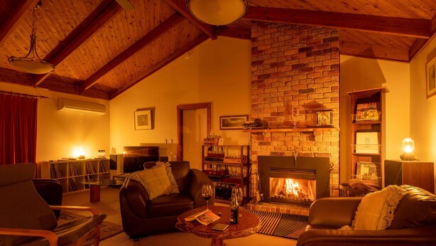 Ein gemütliches Wohnzimmer mit Kamin, Ledersofas und einem Couchtisch.