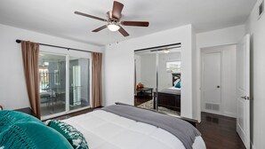 A bedroom with a bed, a ceiling fan, a sliding glass door leading to a balcony, and a door to another room. - Beautiful house close to San Diego Zoo, Sea World, Coronado (Chula Vista)