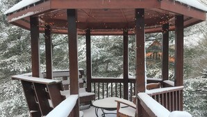 A gazebo with a snow-covered roof and wooden railings, surrounded by snow-laden trees. - Welcome to LAZY DEER CABIN! (Piney Creek)