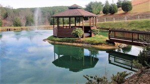 A gazebo by a calm lake with a wooden deck and a bridge. - Welcome to LAZY DEER CABIN! (Piney Creek)