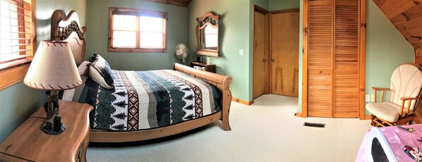 Un dormitorio con una cama de madera, una mesita de noche, una silla, un armario y una ventana con persianas.