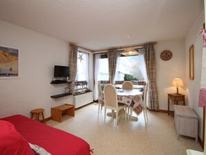 Relax in a comfortable room with a bed, dining area, and workspace.