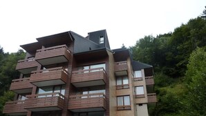 A multi-story building with balconies and large windows.