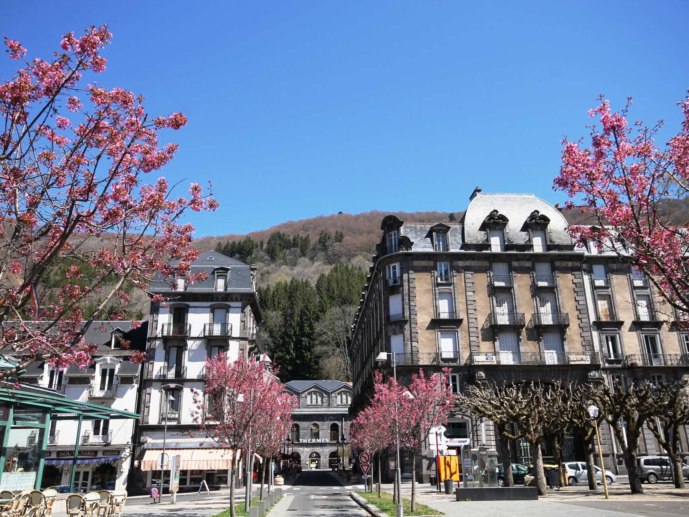A street lined with buildings, including a hotel with a sign 'THERMES'.