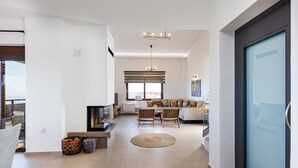 Amplia sala de estar con chimenea, un conjunto de sofás y un comedor.