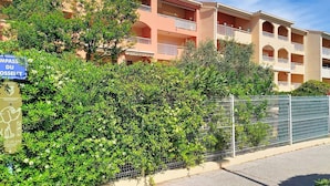 A multi-story hotel with balconies, a sign indicating a dog-friendly area, and a metal fence.