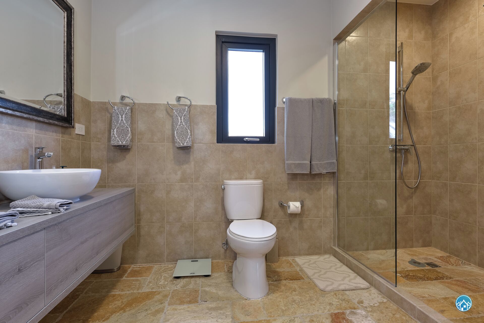 A modern bathroom with a large sink, toilet, and shower.
