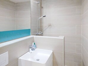 A bathroom with a shower, a bathtub, and a sink.