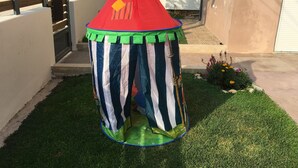 A small, colorful play tent in a backyard. - Beach House (artemida)