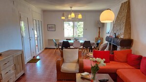 A spacious living area with a dining table, chairs, a sofa, and a coffee table. - Villa Catabella with unlimited WiFi internet next to the beaches and the village (L'Escala)