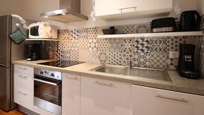 Una cocina moderna con armarios blancos, un lavamanos de acero inoxidable y un salpicadero decorativo.