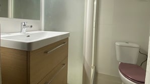 Ein Badezimmer mit Waschbecken, Holzschrank und Toilette.