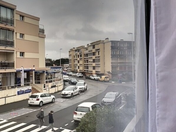 A multi-story building with a pedestrian crossing and parked cars.