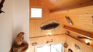 A wooden interior with a mounted animal hide, a small window, and various mounted items. - Spacious 3* chalet with parking and WiFi in Mont Dore (Mont-Dore)