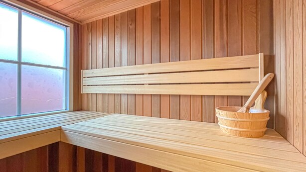 A wooden sauna bench with a slatted backrest and a wooden bucket with a mallet. - Gorgeous home in Hoge Hexel with sauna (Hoge Hexel)