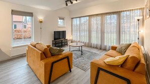 A modern living room with two sofas, a coffee table, and a TV. - Gorgeous home in Hoge Hexel with sauna (Hoge Hexel)