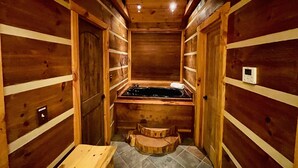 Una sauna de madera con un banco, una mesita y un panel de control en la pared.