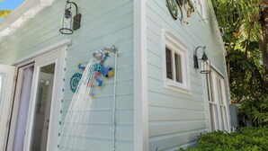 Une maison à l’extérieur bleu clair, avec une fenêtre à cadre blanc et une petite fenêtre également à cadre blanc.
