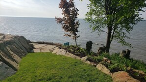 A grassy area with a stone pathway leading to a body of water.