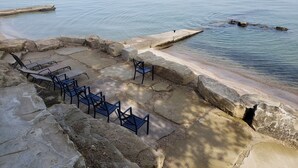 A stone patio with outdoor seating by the sea.