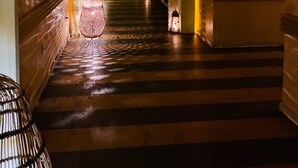 A corridor with ornate arches and a chandelier.