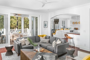 Relax in this inviting living space with a sofa, coffee table, and kitchen area, offering a view of the outdoors.