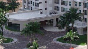 A high-rise building with multiple floors, a central courtyard, and surrounding greenery. - Beachfront 1 br. condo with private hot tub at Gran Venetian Puerto Vallarta (Puerto Vallarta)