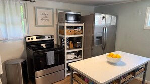 A kitchen with a stove, oven, microwave, refrigerator, and a table with a bowl of lemons. - Wet Feet Retreat! Lake front cabin in quiet cove. (Caddo)