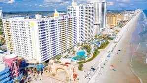 Ein Hochhaus-Hotel mit mehreren Stockwerken, einem Poolbereich und einer Strandlage.