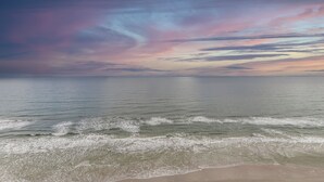 Ein Strand mit Wellen und einem farbenprächtigen Himmel.