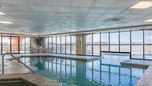 An indoor swimming pool with clear views of the city skyline through large windows. - Harbour Place 204 - white sands, and beach view! (Orange Beach)