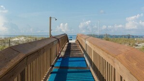 A wooden boardwalk leading to the beach with a clear view of the ocean and sandy dunes. - Harbour Place 204 - white sands, and beach view! (Orange Beach)