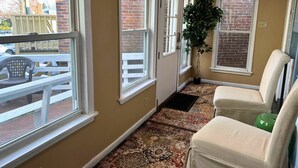 A room with large windows, a potted plant, and a patterned carpet. - On Main Street - Apartment C  - Berlin, MD (Berlin)