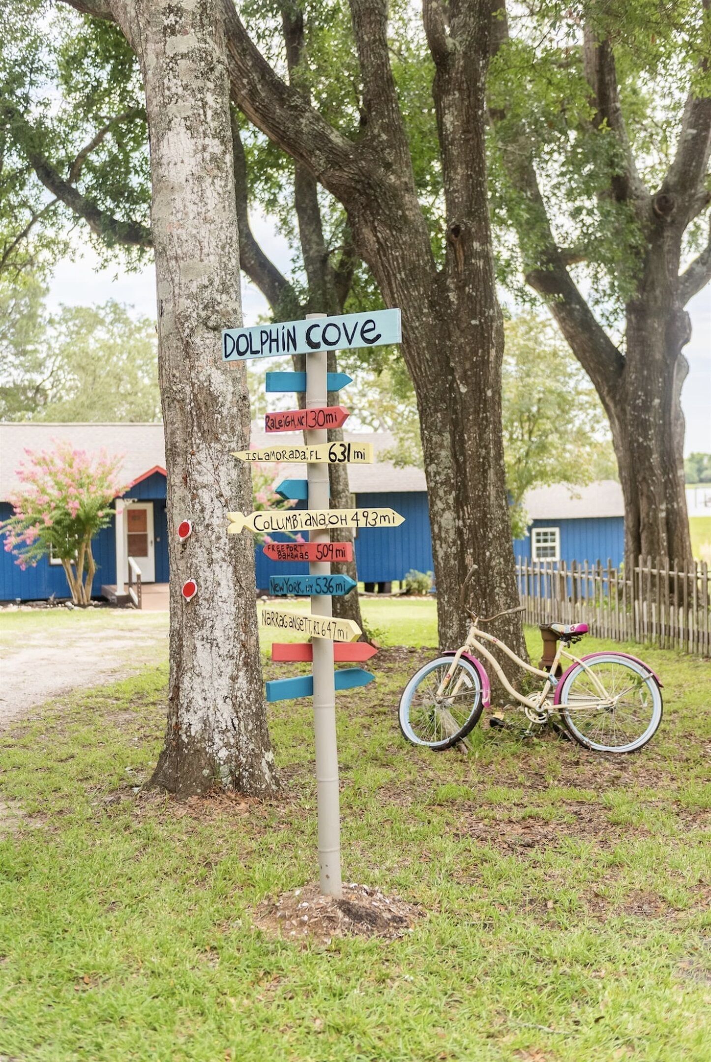 A directional signpost with multiple destination markers, including 'Dolphin Cove' and distances to various locations.