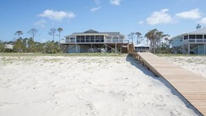 A beach house with a wooden deck leading to a covered area. - Spacious Gulf Front Home on Extra Wide Lot! (Port St. Joe)