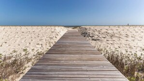 A wooden boardwalk leading to a beach with sand dunes and sparse vegetation. - Spacious Gulf Front Home on Extra Wide Lot! (Port St. Joe)