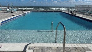 A clear blue pool with a view of the ocean and beach in the background. - On the beach (Daytona Beach)