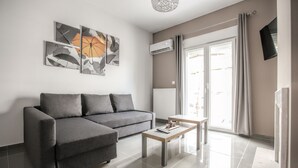 A modern living room with a grey sofa, a coffee table, and abstract artwork on the wall.